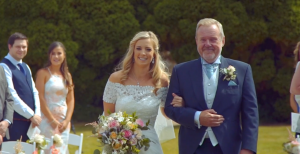 Bride walking with father down aisle